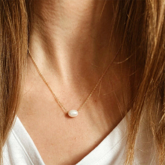 Professional model wearing the gold baroque pearl necklace with a crisp white t-shirt.