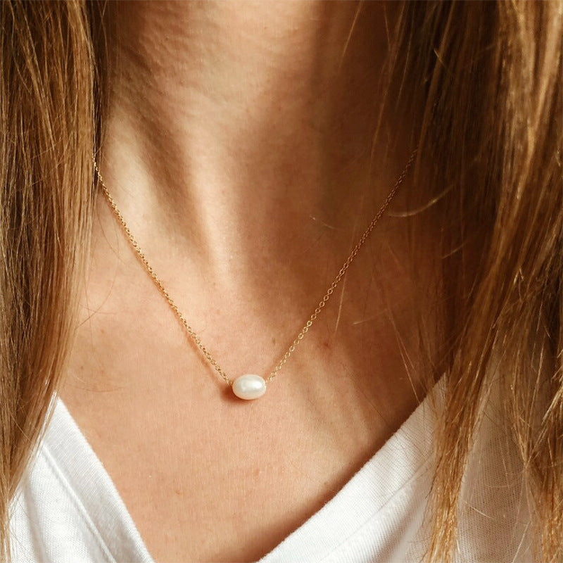 Professional model wearing the gold baroque pearl necklace with a crisp white t-shirt.