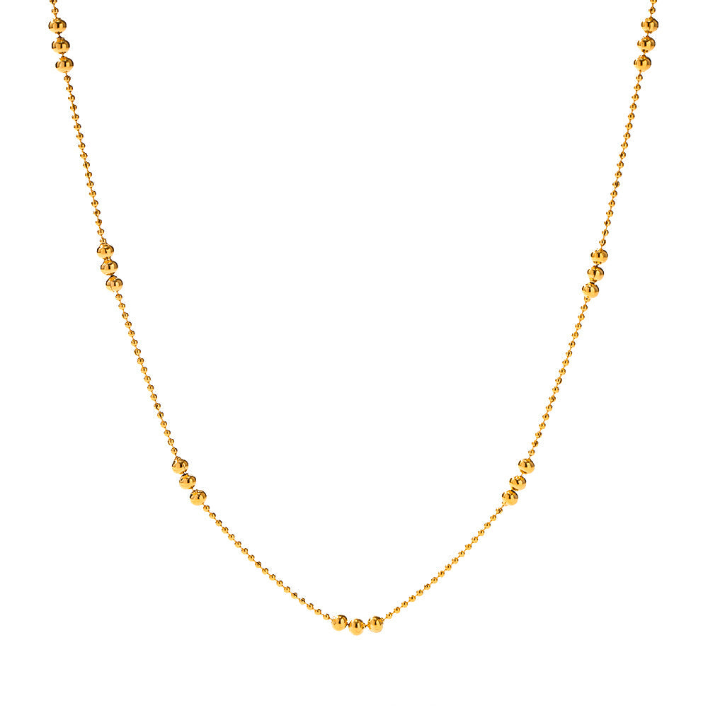 Clean studio shot of the gold ball chain necklace vertically displayed against a white background.