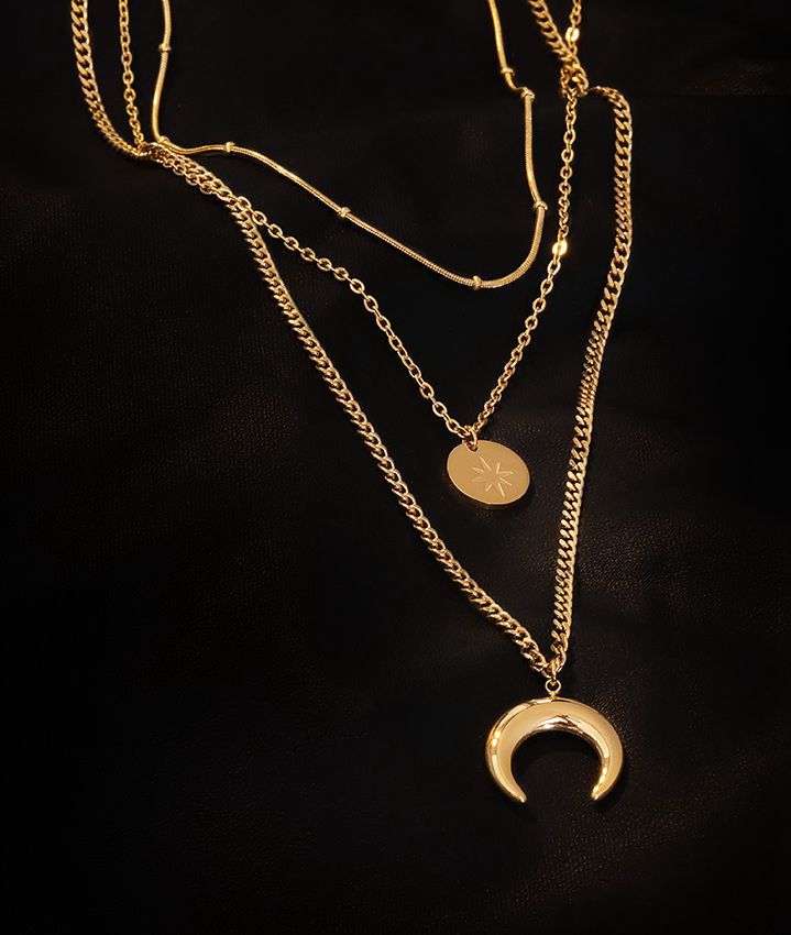 Detailed shot of a 304 stainless steel layered necklace featuring a sun disc and crescent moon pendant.