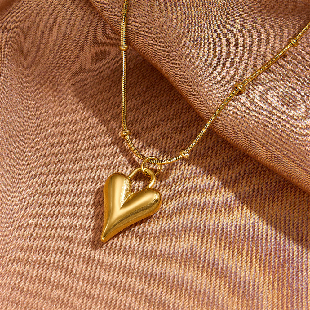 Detailed view of the high-polish gold heart pendant showing the secure attachment to the non-tarnish chain.