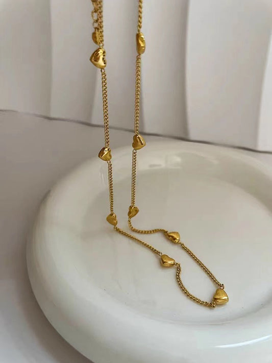 Detailed view of the non-tarnish stainless steel heart chain resting on a white ceramic plate.