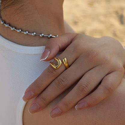 Lifestyle shot of a model wearing the gold organic open ring on her finger, styled with a white ribbed top.