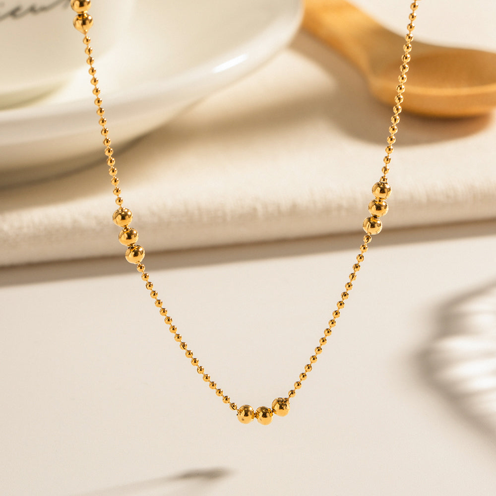 Macro shot focusing on the high-polish finish of the gold bead clusters on the non-tarnish chain.