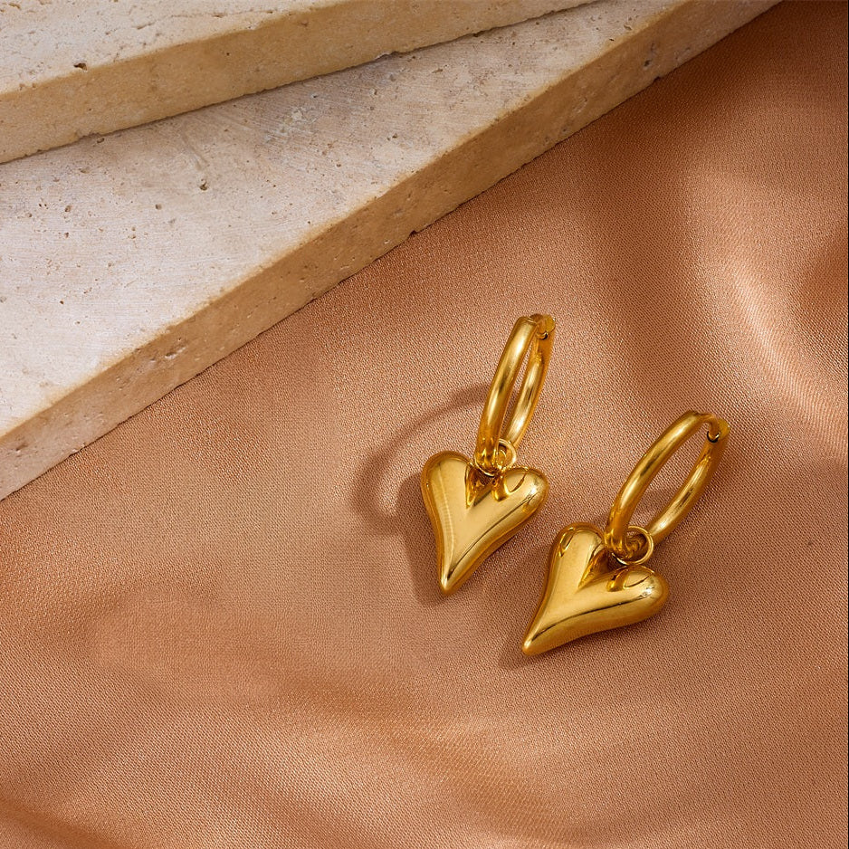 Pair of 18K gold plated drop hoop earrings with 3D puffy heart charms.
