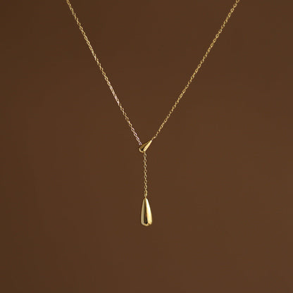 Studio portrait of the gold lariat necklace showing the elegant drop of the two teardrop pendants.