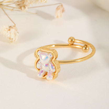 A cute gold adjustable ring featuring a translucent, iridescent gummy bear charm with a pearlescent finish.